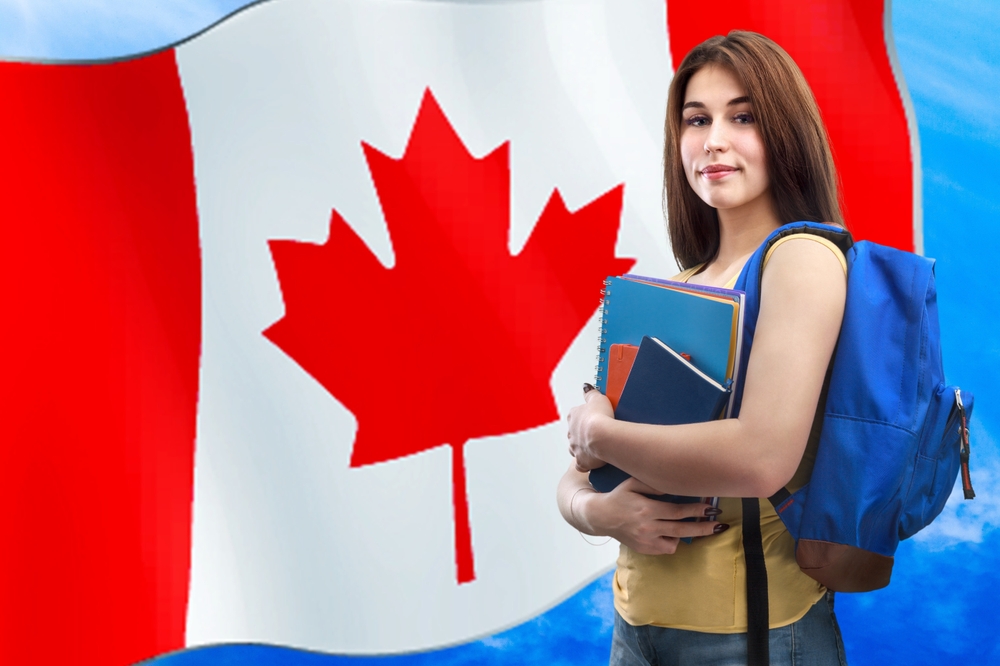 Happy,Young,Student,With,Books,And,Canada,Flag